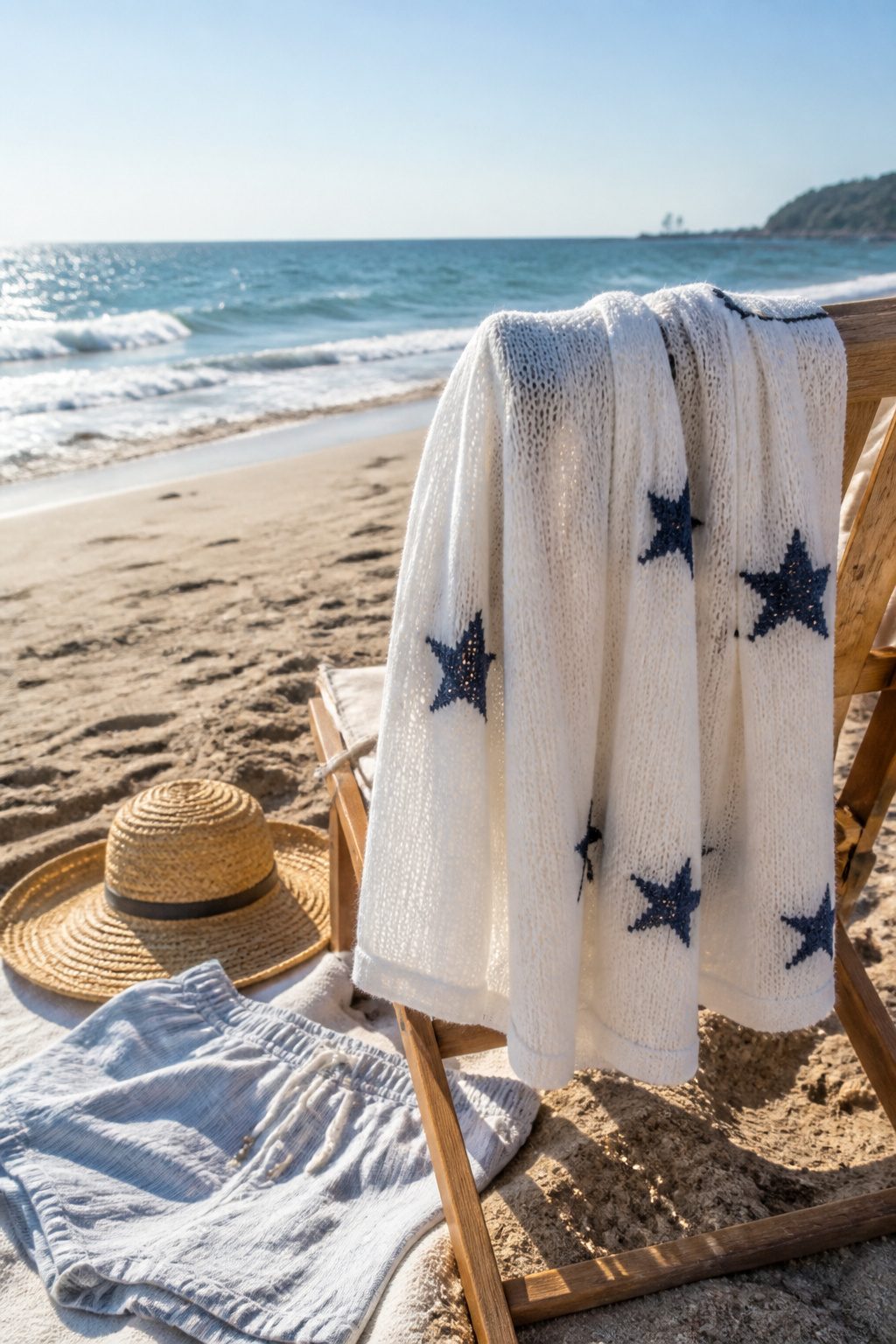 Star hoodie sweater draped on a beach chair.