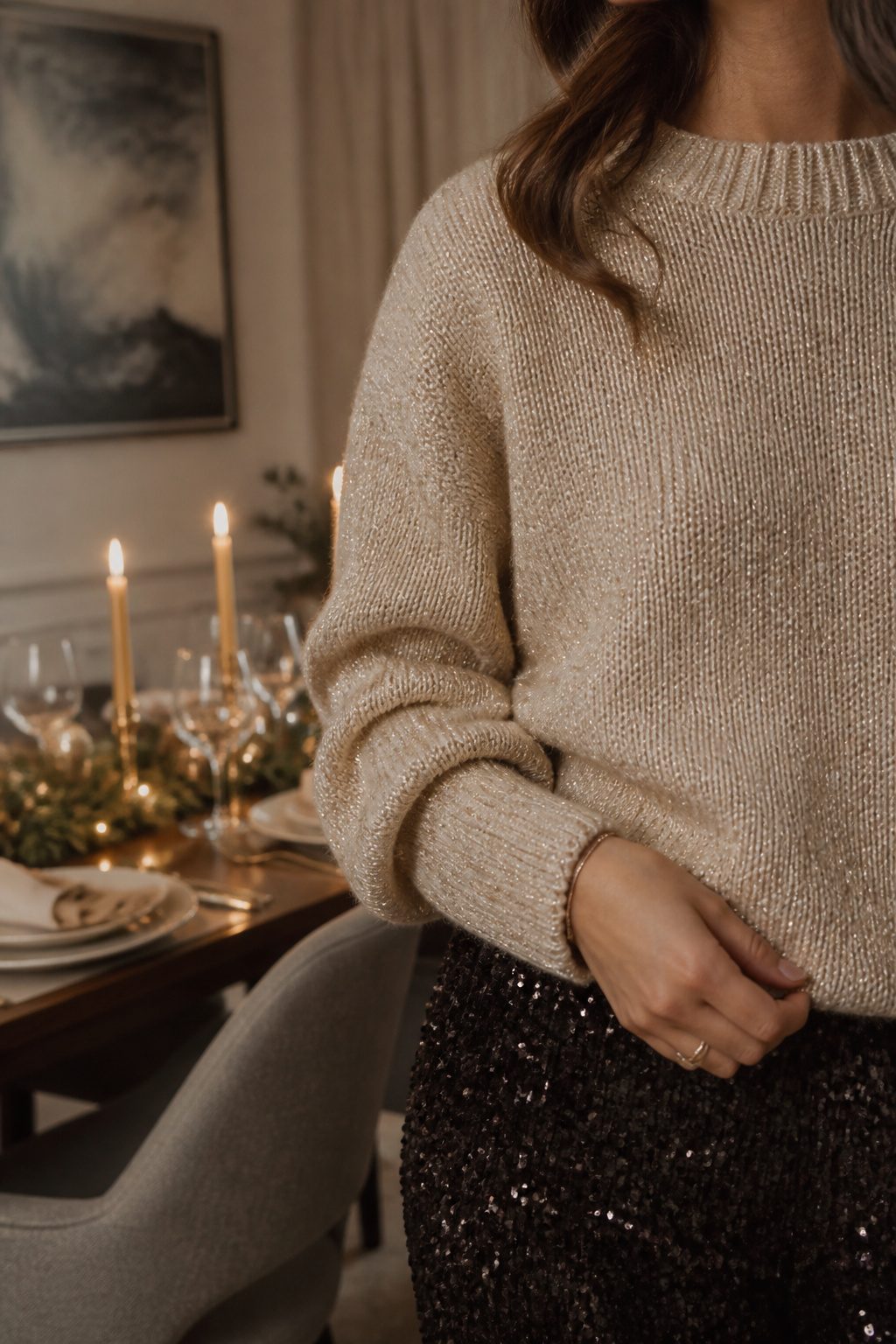 A knit sweater with metallic threads in a softly lit dining area.