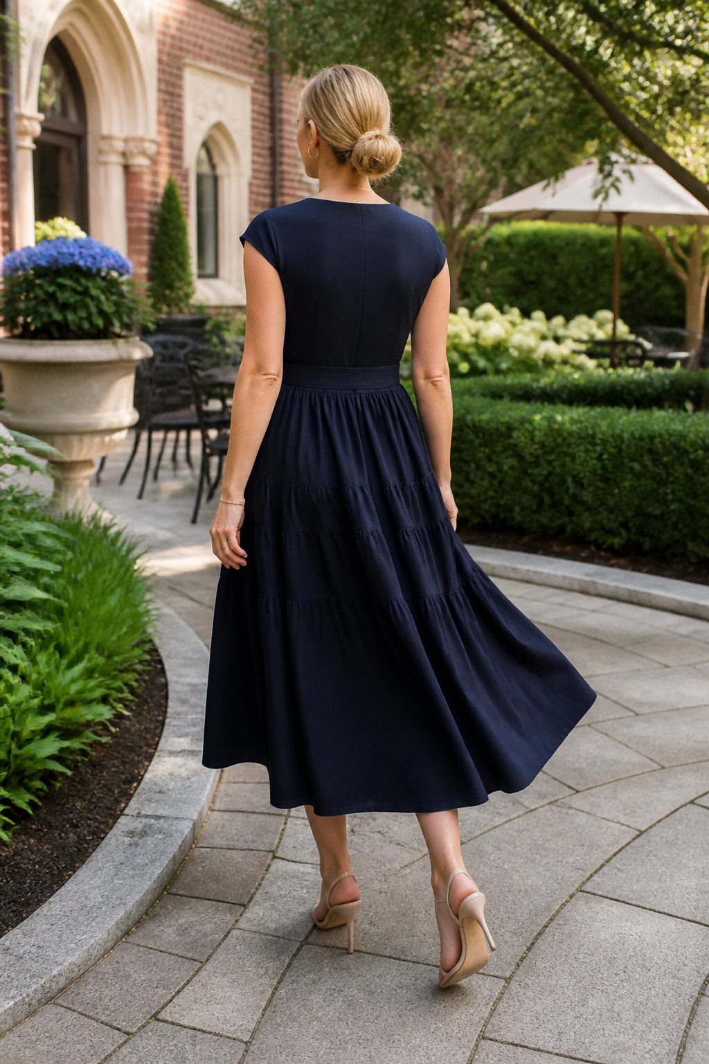 A woman in the Tanya Taylor Mixed-Media Midi Dress in a campus courtyard.